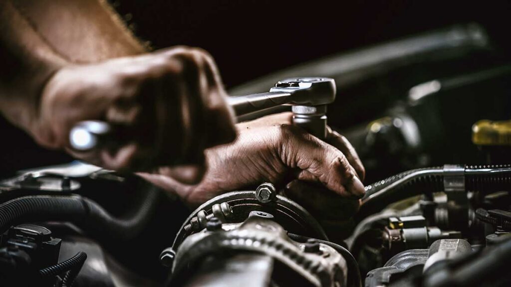 man repairing transmission porsche